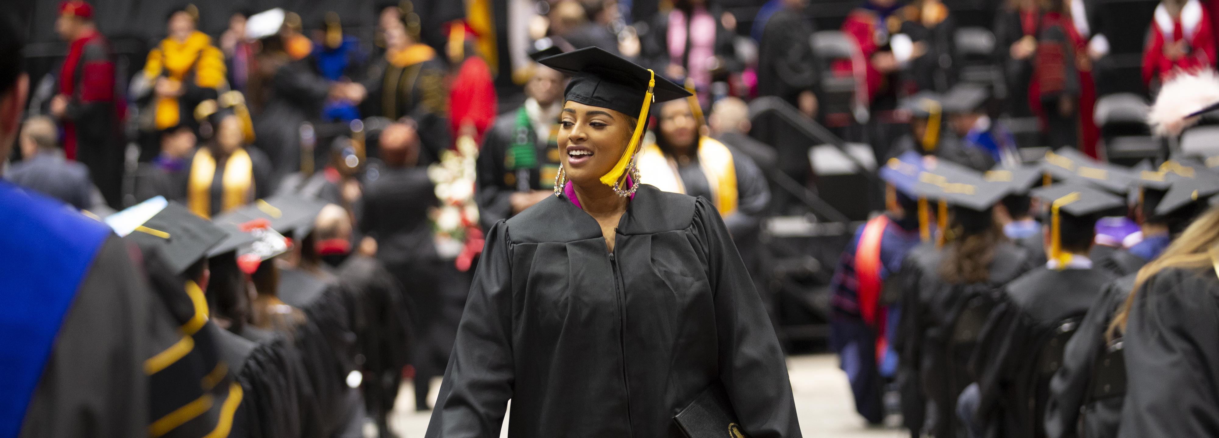 Graduate walks down aisle for processional.
